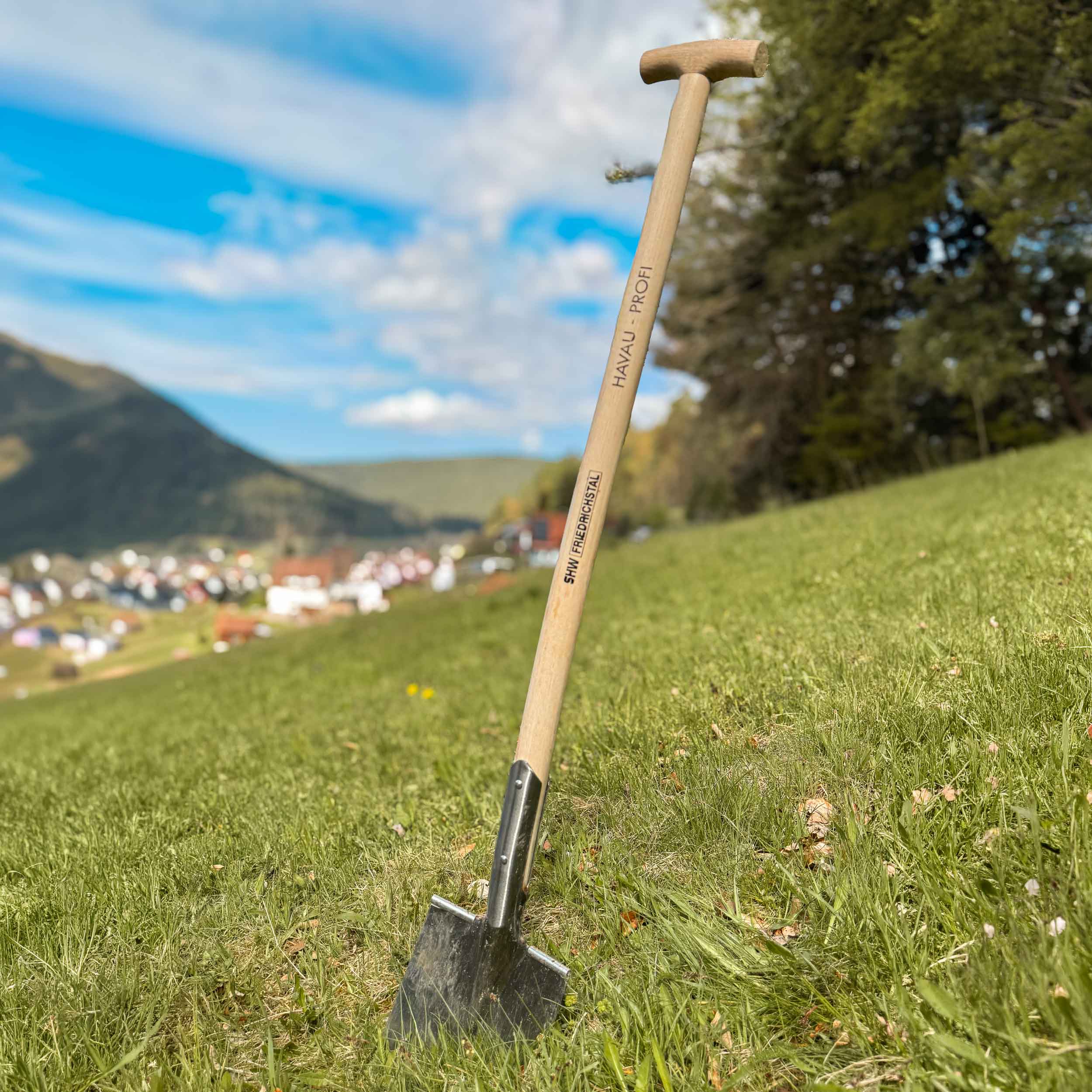 Drainagespaten mit T-Holzgriff und schmalem Stahlblatt steht auf Wiese – robuster Schmalspaten für Gräben, Gartenarbeit und Landschaftsbau